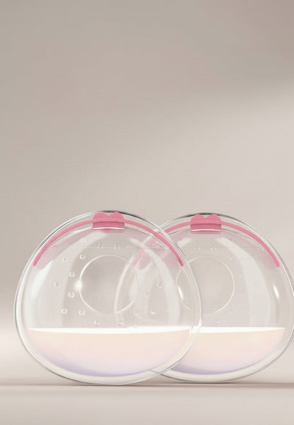 momviacare clear silicone breast milk collectors with pink trim, shown discreetly inside a bra and also as a pair.