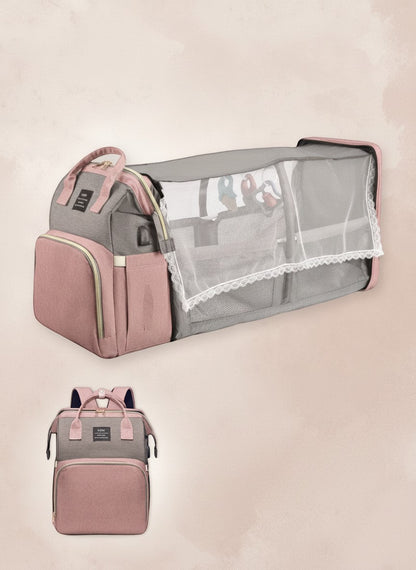 momviacare grey and dusty rose transformable backpack that unfolds into a bassinet with toy arch and changing station.